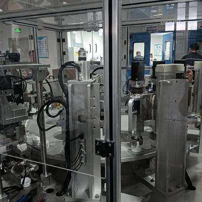 Machine d'assemblage de bouchons de détergent liquide automatisée non standard, capable d'être opérée par une seule personne simultanément sur deux unités.